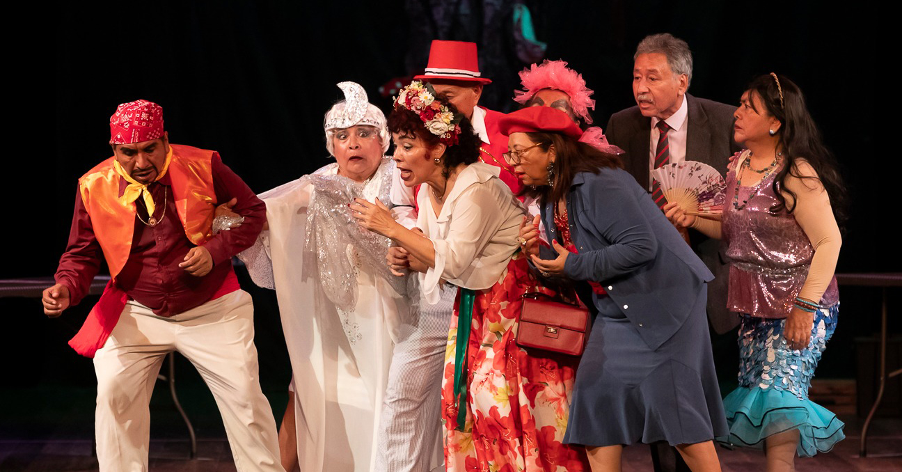 Un fotografía con ocho actores y actrices del proceso Teatro Voces Mayores de 2024 durante la representación de una obra.